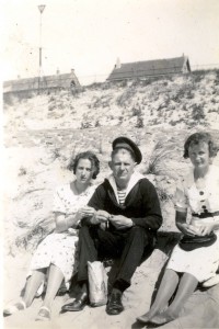 Matroos Eeuwe D. Bakker, geboren op 6-9-1910 was in 1939 opgeroepen om zich in Den Helder te melden. Met de Hr.Ms. Jacob van Heemskerk kwam hij in IJmuiden terecht tijdens de mobilisatie. Hij zit hier, waarschijnlijk bij IJmuiden, op het strand met zijn vrouw Greet (Margaretha) de Jong en Rimkje Visser (getrouwd met Hendrik de Boer) Tijdens de oorlogsdagen week de kruiser, die nog niet was afgebouwd, uit naar Engeland. Daar deed Eeuwe Bakker dienst als bommenlader op verschillende vliegvelden. Eind 1944 werd hij overgeplaatst naar Belgie en kon zo in 1945 naar huis terugkeren. (foto 15 augustus 1939)