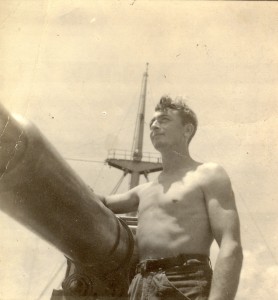 Geert de Vries poseert bij een kanon. Foto is waarschijnlijk gemaakt tijdens de oorlog. Geert de Vries was tijdens de mobilisatie als matroos ingedeeld bij de Koninklijke Marine. Voor het uitbreken van de oorlog ging hij weer naar zee bij de koopvaardij. Hij heeft de hele oorlog gevaren. (foto 23 juli 1943)
