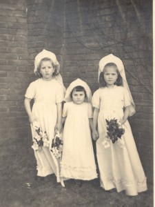 Drie meisjes poseren in bruidsjurkjes die gemaakt zijn van stof van parachutes. De stof was erg gewild voor bruidskleding. In het midden Hannie de Boer. (foto 29 juli 1946)