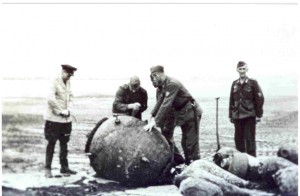 Opruimen van een aangespoelde explosieven en zeemijn op het ZuidWest bij Hollum, door Oberstabsfeldwebel Gerhard. De explosievenexpert van de Marine flakabteilung 246 reisde rond door de afdeling, hieronder vielen Terschelling, Vlieland en Ameland Hij kwam in 1942 om het leven bij het onschadelijk maken van een magnetische mijn op Vlieland. (foto 10 september 1941)