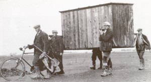 In de NO polder verplaatsen tewerkgestelde Nederlanders een keet. (foto 29 oktober 1944)