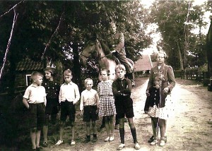 Kinderen in Nes poseren voor een Duitse soldaat te paard. (foto 8 juli 1941)