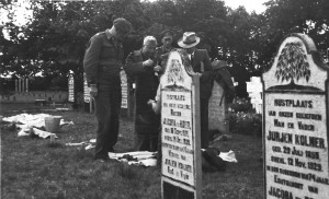 Identificatie van op de algemene begraafplaats te Nes begraven slachtoffers van de oorlog.  (foto 10 september 1945)