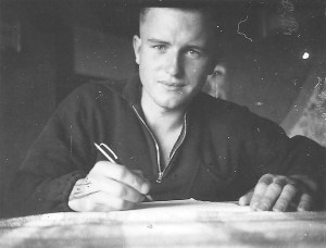 Jonge Duitse soldaat is bezig met het schrijvenvan een brief gezeten aan een tafel in hun verblijf. Foto genomen in het eerste jaar van de oorlog.  (15 december 1940)