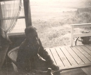 Duitse soldaat zit aan tafel in een zomerhuisje dat gebruikt wordt als soldatenverblijf bij Nes. (foto 20 september 1940)