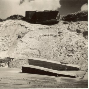 Een Duitse bunker verdwijnt lanzamerhand in zee door duinafslag bij Hollum. (foto d.d. 11 december 1955)