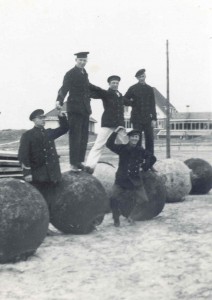Marinepersoneel opgesteld op een serie zeemijnen. Op de foto geheel links Gosling Postmus en met witte broek Hendrik Nienhuis. De foto is genomen tijdens de mobilisatie aan het einde van de Strandweg van Nes. Op de achtergrond zien we Hotel Scheltema. We mogen aannemen dat de mijnen onschadelijk zijn gemaakt. (foto 20 oktober 1939)